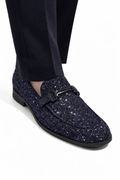 Navy glitter loafers worn with black pants on a white background