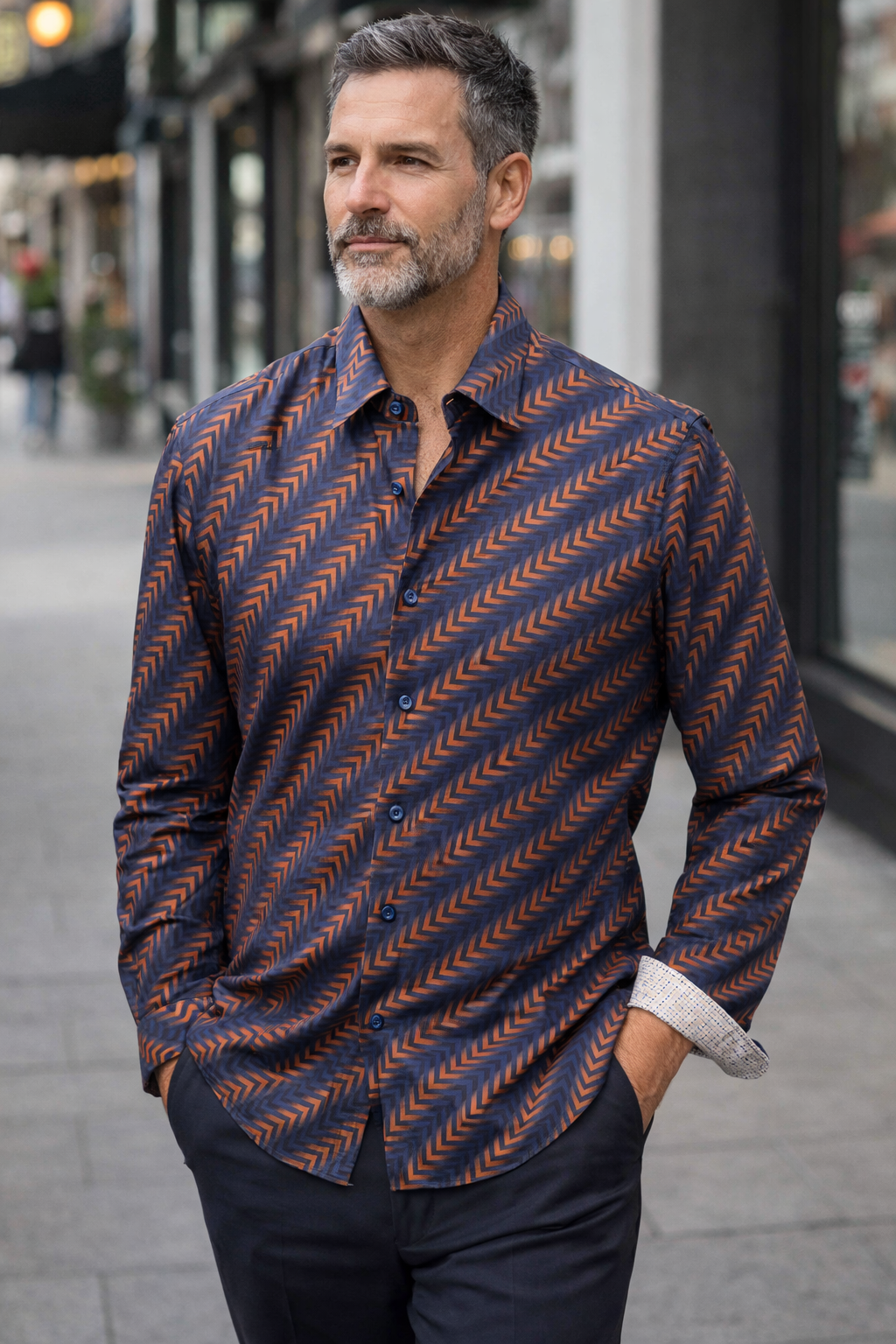 Man wearing a patterned shirt standing on a city street