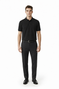Man wearing a black polo shirt and black pants on a white background