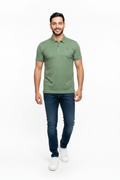 Man wearing a green polo shirt and blue jeans on a white background