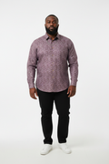 Man wearing a patterned shirt and black pants on a white background